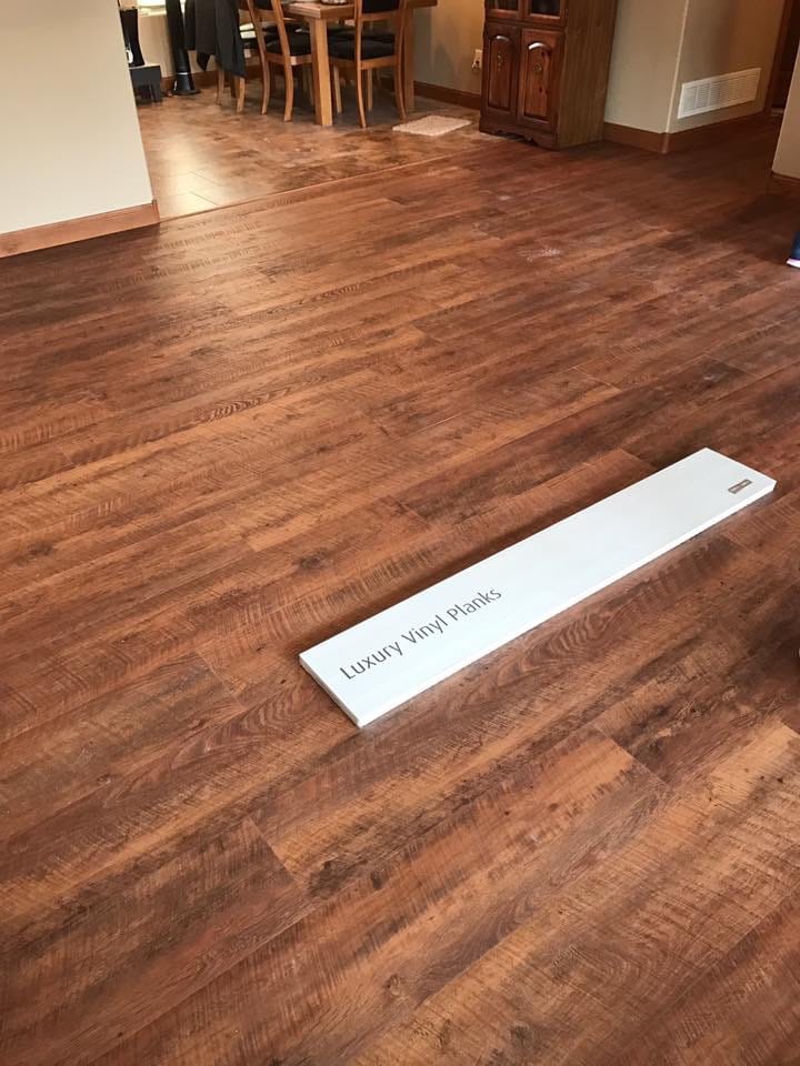 luxury vinyl planks with an extra box of planks laying on top of the surface