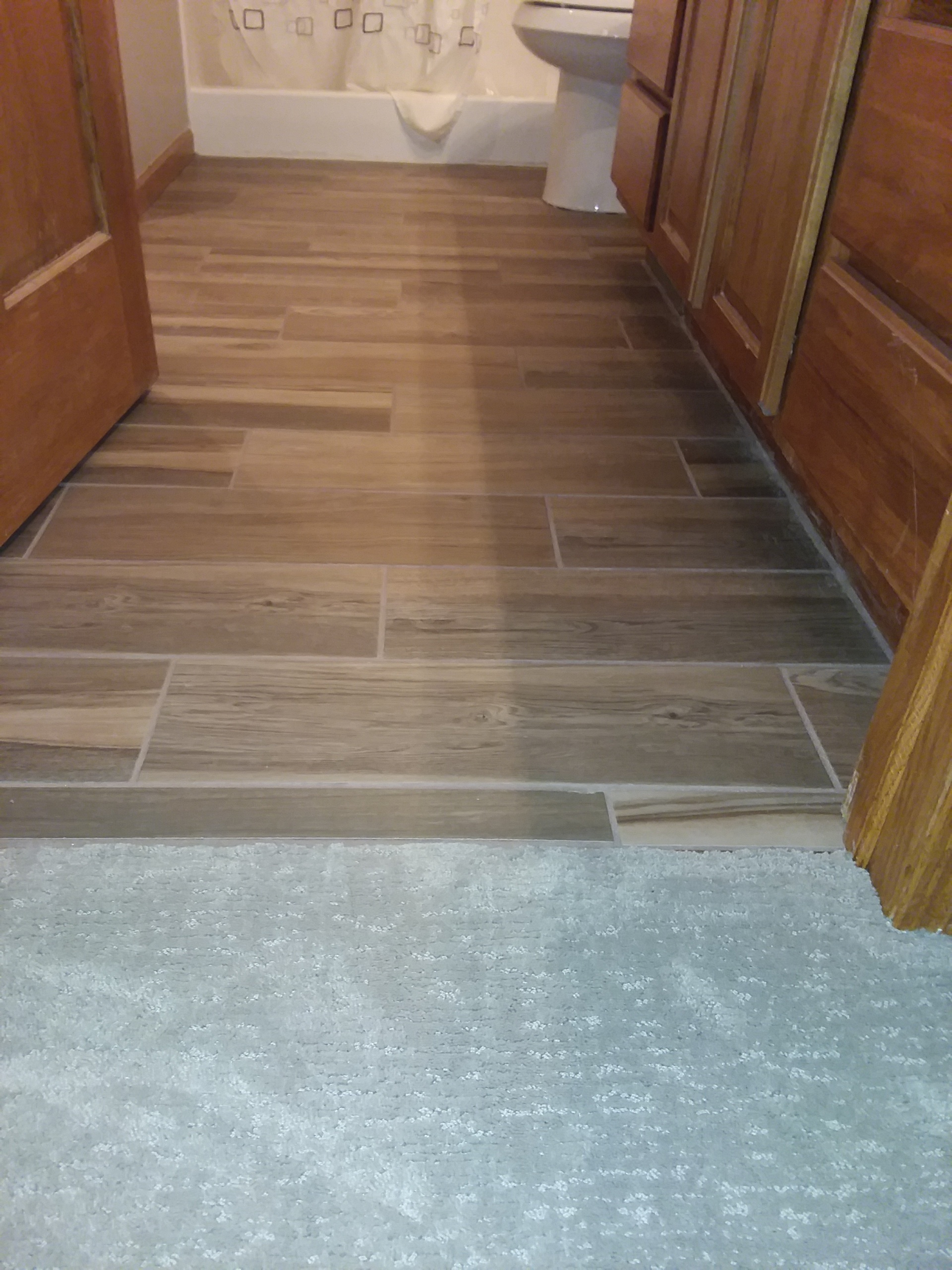 carpet hallway to tile bathroom
