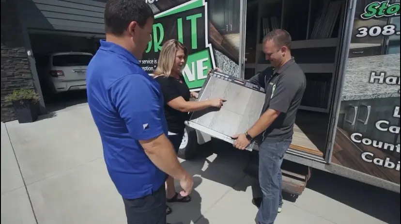 dustin presenting flooring ideas to customers in their driveway